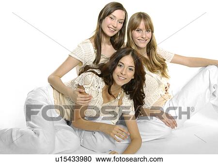 Portrait of three young women sitting together and smiling View Large Photo Image Stock Image - Portrait of three young women sitting together and smiling. Fotosearch