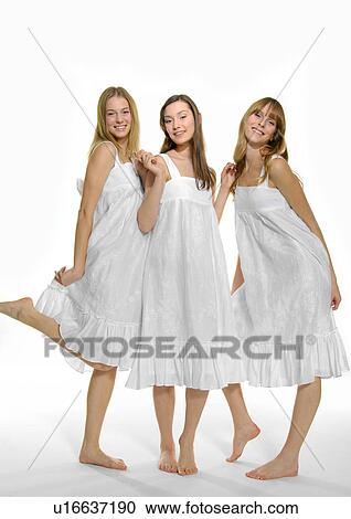 Stock Image - Portrait of three young women standing together. Fotosearch