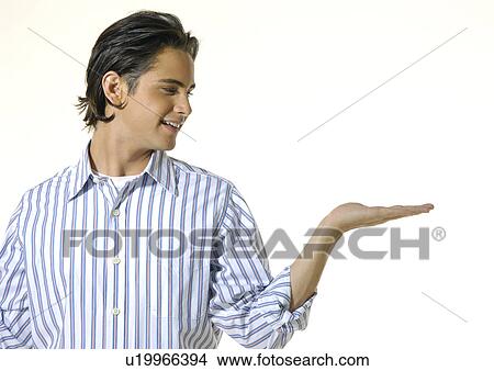 Close-up of a young man looking towards his left hand View Large Photo Image Picture - Close-up of a young man looking towards his left hand. Fotosearch