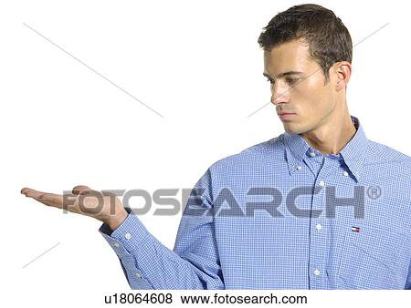 Close-up of a young man looking towards his right hand View Large Photo Image Stock Photo - Close-up of a young man looking towards his right hand. Fotosearch