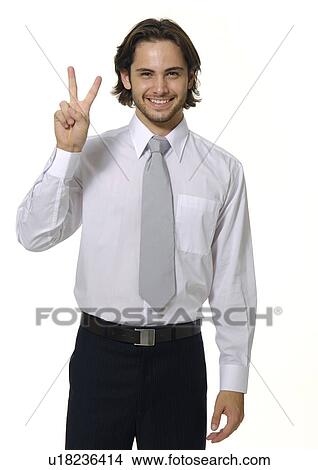 Portrait of a businessman making a peace sign and smiling View Large Photo Image Picture - Portrait of a businessman making a peace sign and smiling. Fotosearch