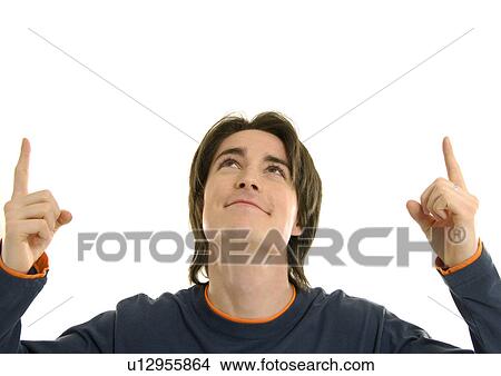 Picture - Close-up of a young man pointing his index fingers upwards. Fotosearch