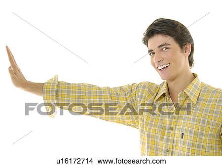 Portrait of a young man making a stop gesture and smiling View Large Photo Image Picture - Portrait of a young man making a stop gesture and smiling. Fotosearch