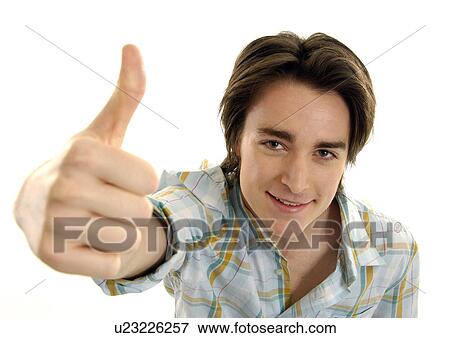 Portrait of a young man making a thumbs up sign View Large Photo Image Stock Photo - Portrait of a young man making a thumbs up sign. Fotosearch