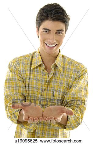 Stock Photography - Portrait of a young man standing with his hands cupped. Fotosearch