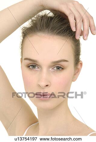 Stock Photo - Portrait of a young woman with her hand on her head. Fotosearch