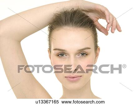 Stock Photography - Portrait of a young woman with her hand on her head. Fotosearch