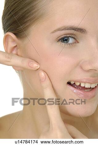 Picture - Portrait of a young woman squeezing pimple . Fotosearch
