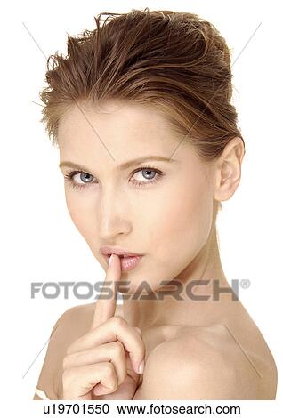Portrait of a young woman with her finger on her lips View Large Photo Image Stock Image - Portrait of a young woman with her finger on her lips. Fotosearch