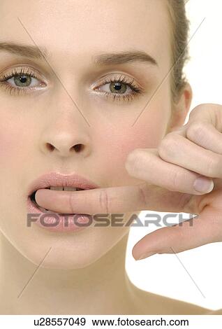 Portrait of a young woman with her finger on her lips View Large Photo Image Stock Photo - Portrait of a young woman with her finger on her lips. Fotosearch