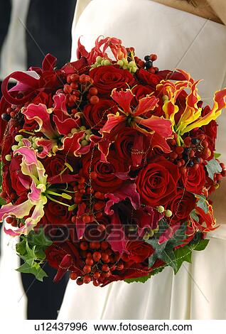 Stock Photograph - Mid section view of a bride holding a bouquet of flowers. Fotosearch