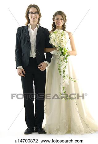 Portrait of a newlywed couple standing with arm in arm and smiling View Large Photo Image Stock Image - Portrait of a newlywed couple standing with arm in arm and smiling. Fotosearch