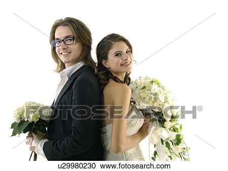 Portrait of a newlywed couple standing back to back and smiling View Large Photo Image Stock Image - Portrait of a newlywed couple standing back to back and smiling. Fotosearch