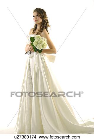 Picture - Side profile of a bride holding a bouquet of flowers. Fotosearch