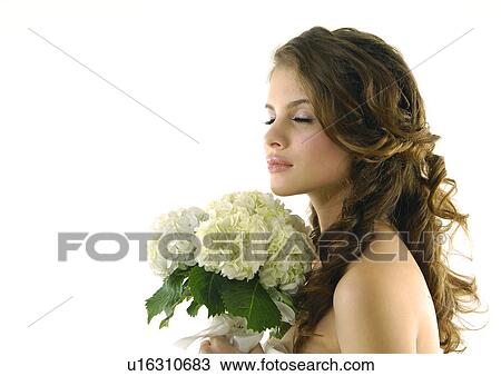 Side profile of a bride holding a bouquet of flowers with her eyes closed View Large Photo Image Stock Image - Side profile of a bride holding a bouquet of flowers with her eyes closed. Fotosearch
