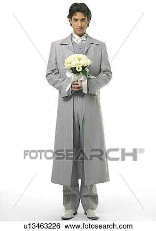 Stock Photograph - Portrait of a groom holding a bouquet of flowers. Fotosearch