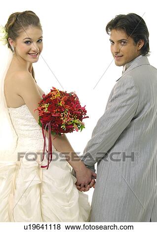 Stock Photo - Portrait of a newlywed couple holding each other's hands and smiling. Fotosearch