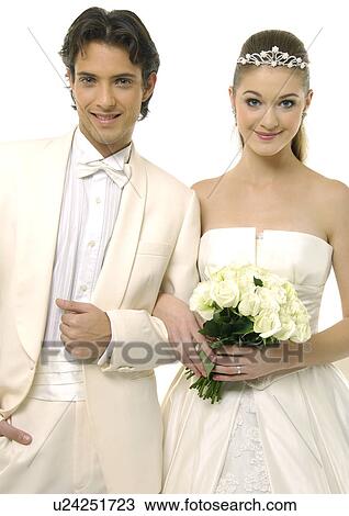 Portrait of a newlywed couple smiling and holding a bouquet of flowers View Large Photo Image Stock Image - Portrait of a newlywed couple smiling and holding a bouquet of flowers. Fotosearch