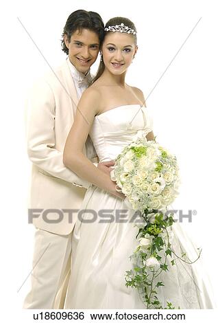 Portrait of a newlywed couple smiling and holding a bouquet of flowers View Large Photo Image Stock Photograph - Portrait of a newlywed couple smiling and holding a bouquet of flowers. Fotosearch