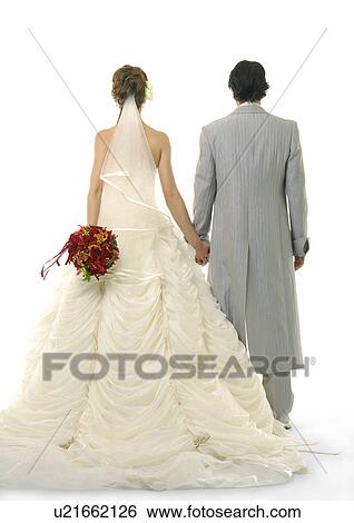 Stock Photograph - Rear view of a newlywed couple holding each other's hands. Fotosearch