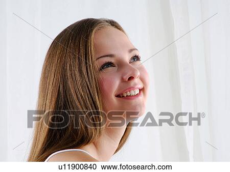 Close-up of a young woman looking up and smiling View Large Photo Image Stock Image - Close-up of a young woman looking up and smiling. Fotosearch