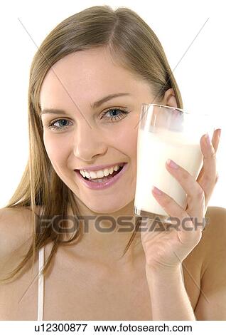 Portrait of a young woman holding a glass of milk and smiling View Large Photo Image Stock Photo - Portrait of a young woman holding a glass of milk and smiling. Fotosearch