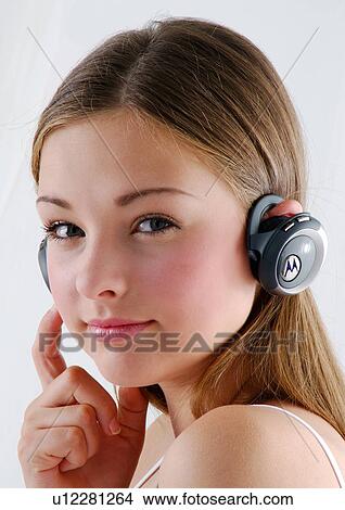 Portrait of a young woman wearing headphones and listening to music View Large Photo Image Picture - Portrait of a young woman wearing headphones and listening to music. Fotosearch