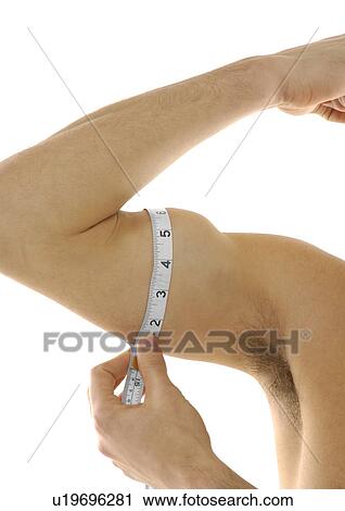 Stock Image - Close-up of a person measuring his biceps. Fotosearch