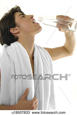 Close-up of a young man drinking a bottle of water View Large Photo Image Stock Image - Close-up of a young man drinking a bottle of water. Fotosearch
