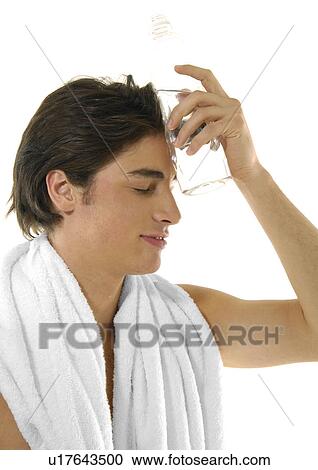 Close-up of a young man holding a bottle of water on his head View Large Photo Image Stock Image - Close-up of a young man holding a bottle of water on his head. Fotosearch
