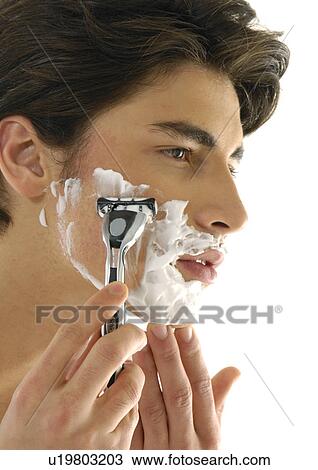 Stock Image - Close-up of a young man shaving. Fotosearch