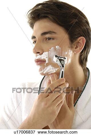Close-up of a young man shaving View Large Photo Image Stock Photo - Close-up of a young man shaving. Fotosearch
