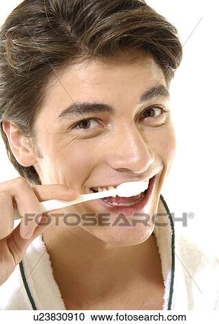 Portrait of a young man brushing his teeth View Large Photo Image Stock Image - Portrait of a young man brushing his teeth. Fotosearch