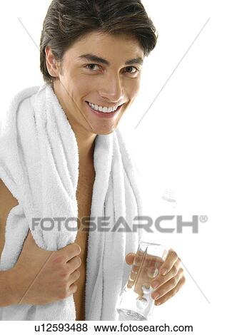 Portrait of a young man holding a bottle of water and smiling View Large Photo Image Stock Photo - Portrait of a young man holding a bottle of water and smiling. Fotosearch