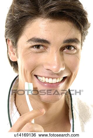 Portrait of a young man holding a toothbrush View Large Photo Image Stock Photograph - Portrait of a young man holding a toothbrush. Fotosearch