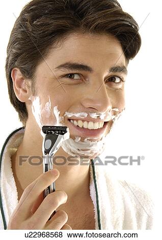 Portrait of a young man shaving and smiling View Large Photo Image Stock Photo - Portrait of a young man shaving and smiling. Fotosearch