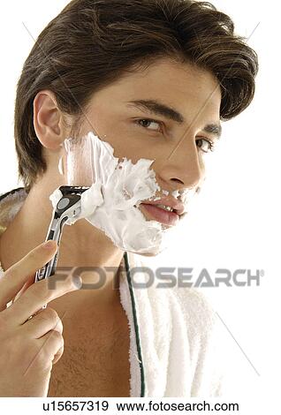 Portrait of a young man shaving View Large Photo Image Stock Photo - Portrait of a young man shaving. Fotosearch