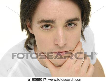 Stock Photo - Portrait of a young man with his hand on his chin. Fotosearch