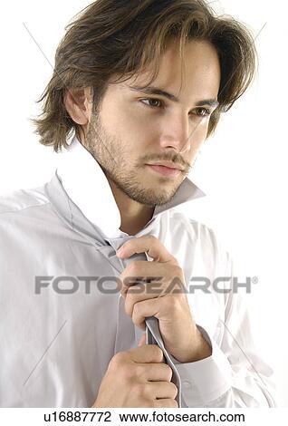 Close-up of a young man tying his tie View Large Photo Image Stock Image - Close-up of a young man tying his tie. Fotosearch