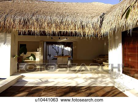 Stock Image - Bungalow with a thatched roof. Fotosearch