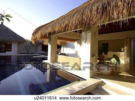 Bungalows with thatched roofs near a swimming pool View Large Photo Image Picture - Bungalows with thatched roofs near a swimming pool. Fotosearch