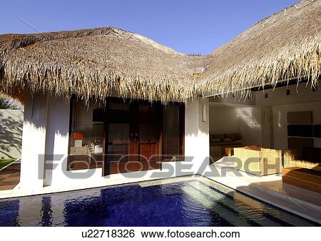 Bungalows with thatched roofs near a swimming pool View Large Photo Image Stock Photograph - Bungalows with thatched roofs near a swimming pool. Fotosearch