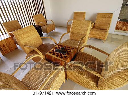 Four rattan chairs in a room View Large Photo Image Stock Image - Four rattan chairs in a room. Fotosearch
