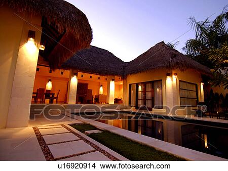 Swimming pool and a house lit up at night View Large Photo Image Picture - Swimming pool and a house lit up at night. Fotosearch