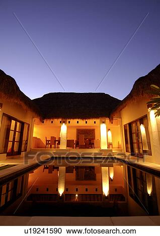 Swimming pool and a house lit up at night View Large Photo Image Stock Image - Swimming pool and a house lit up at night. Fotosearch