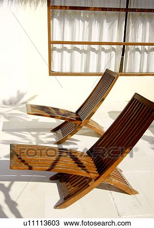 Two poolside chairs near a wall View Large Photo Image Stock Image - Two poolside chairs near a wall. Fotosearch