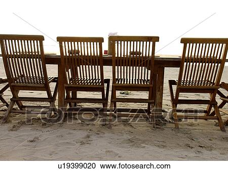 View of a row of folding chairs on a beach. View Large Photo Image Stock Image - View of a row of folding chairs on a beach.. Fotosearch