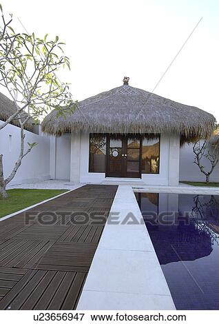 View of a thatched roof room near a swimming pool, Bvilla+Spa. View Large Photo Image Stock Photo - View of a thatched roof room near a swimming pool, Bvilla+Spa.. Fotosearch