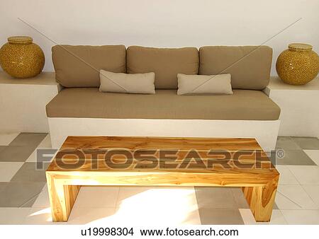 Picture - Wooden coffee table in front of a couch. Fotosearch