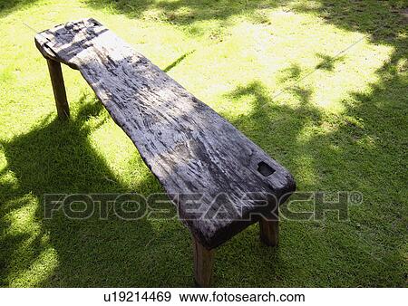 Stock Photo - High angle view of a wooden bench on a lawn. Fotosearch